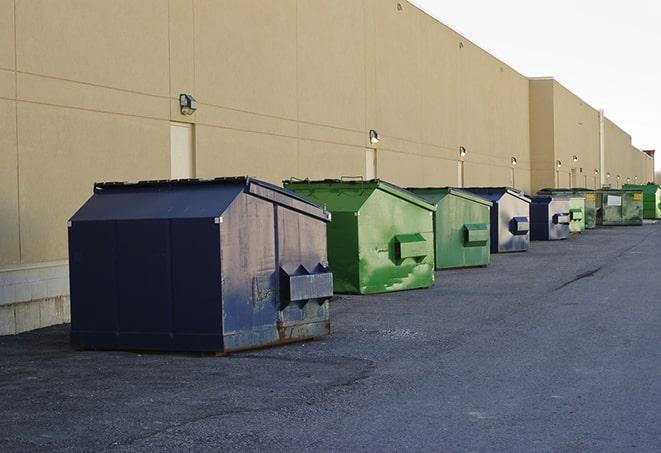 a construction worker empties a wheelbarrow of waste into the dumpster in Dover FL